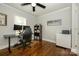 Home office with hardwood floors, large desk, and built-in shelving at 7445 Briardale Dr, Charlotte, NC 28212