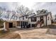 Rear view of house, showcasing patio, screened porch, and landscaping at 7445 Briardale Dr, Charlotte, NC 28212