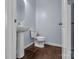 Small powder room with pedestal sink and dark wood flooring at 7822 Meridale Forest Dr, Charlotte, NC 28269