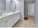 Bathroom featuring double sinks with white cabinetry and a walk-in shower, offering convenience and style at 7822 Meridale Forest Dr, Charlotte, NC 28269
