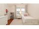 Bright bedroom with twin bed, bookcase, and floral curtains at 808 E Worthington Ave, Charlotte, NC 28203