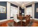 Dark-blue dining room with a wooden table, chandelier, and hardwood floors at 808 E Worthington Ave, Charlotte, NC 28203