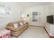 Bright living room features a beige sofa, white shutters, and hardwood floors at 808 E Worthington Ave, Charlotte, NC 28203