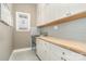 Bright laundry room with ample cabinetry and butcher block countertop at 9929 Allyson Park Dr, Charlotte, NC 28277