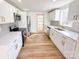 Modern kitchen featuring white cabinets, stainless steel appliances, and wood-look vinyl flooring at 1003 W 4Th Ave, Gastonia, NC 28052