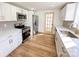 Modern kitchen featuring white cabinets, stainless steel appliances, modern backsplash, and wood-look vinyl flooring at 1003 W 4Th Ave, Gastonia, NC 28052