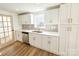 Updated kitchen featuring white cabinets, stainless steel appliances, modern backsplash, and wood-look vinyl flooring at 1003 W 4Th Ave, Gastonia, NC 28052