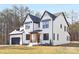 Two-story white brick home with black accents, a gray roof, and a two-car garage at 10517 S Hampton Dr, Charlotte, NC 28227