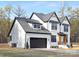 Two-story white brick home with black accents, a gray roof, and a two-car garage at 10517 S Hampton Dr, Charlotte, NC 28227