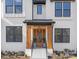 Inviting front entrance with a wooden door and modern light fixture at 10517 S Hampton Dr, Charlotte, NC 28227