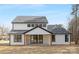 Modern farmhouse exterior with covered patio, large windows, and gray roof at 10517 S Hampton Dr, Charlotte, NC 28227