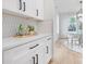 White kitchen with hexagonal tile backsplash and modern cabinetry at 10517 S Hampton Dr, Charlotte, NC 28227