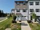 Two-story townhome with gray siding, light blue door, and two-car garage at 11005 Woodland Creek Way, Charlotte, NC 28262