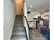 Modern staircase with white railing and kitchen view at 11005 Woodland Creek Way, Charlotte, NC 28262