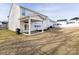 Rear view of a two-story house with a covered patio and a spacious backyard at 11021 Ogden Ln, Charlotte, NC 28278