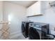 Laundry room with washer, dryer, and overhead cabinets at 11021 Ogden Ln, Charlotte, NC 28278