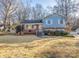 Ranch style home with brick and light blue siding, featuring a well-manicured lawn and mature trees at 1224 Castlegate St, Gastonia, NC 28054