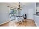 Bright dining area featuring wood floors, a stylish chandelier, and sliding glass doors to the outdoor deck at 12338 Shadow Ridge Ln, Charlotte, NC 28273