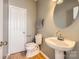 Well-lit half bathroom with pedestal sink and hardwood floors at 12338 Shadow Ridge Ln, Charlotte, NC 28273