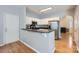 Modern kitchen with stainless steel appliances, white cabinets, and open breakfast bar with wood floors at 12338 Shadow Ridge Ln, Charlotte, NC 28273