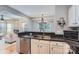 Cozy kitchen showcasing stainless steel appliances, white cabinets, dark countertops, and open view to living area at 12338 Shadow Ridge Ln, Charlotte, NC 28273