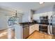 Well-appointed kitchen featuring stainless steel appliances, white cabinetry, and wood flooring, open to dining at 12338 Shadow Ridge Ln, Charlotte, NC 28273