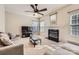 Cozy living room with fireplace, plush seating, and natural light from the large window at 12338 Shadow Ridge Ln, Charlotte, NC 28273