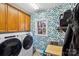 Laundry room with wooden cabinets, patterned wallpaper and window at 12710 Winding Ridge Rd, Huntersville, NC 28078