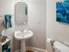 Small powder room with pedestal sink and patterned wall at 12710 Winding Ridge Rd, Huntersville, NC 28078