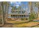 Two-story house with wraparound porch, nestled among trees at 14264 Maple Hollow Ln, Mint Hill, NC 28227