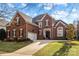 Brick two-story home with a three-car garage and manicured lawn at 15903 Glen Miro Dr, Huntersville, NC 28078