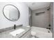 Clean bathroom with gray tile, a bathtub, and a modern vanity at 1938 Grace Ln, Charlotte, NC 28262