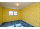 Bedroom with yellow floral wallpaper and blue carpet at 194 Bynum Rd, Lincolnton, NC 28092