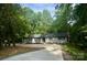 A charming single-story home features a long driveway and a private setting surrounded by lush trees at 217 Ruby Ln, Gastonia, NC 28054