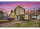 Inviting home featuring a stone chimney, beautiful landscaping, and well lit entry in the dusk at 33287 Mann Rd, Albemarle, NC 28001