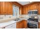 Traditional kitchen with wood cabinets, stainless steel appliances, and a double basin sink by the window at 33287 Mann Rd, Albemarle, NC 28001