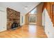 Bright living room with hardwood floors, a stone fireplace, and large windows that offering natural light and lovely views at 33287 Mann Rd, Albemarle, NC 28001