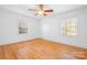 Bright bedroom with hardwood floors, ceiling fan, and two windows at 3515 Back Creek Church Rd, Charlotte, NC 28213