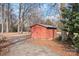 Rustic red storage shed nestled among mature trees at 3515 Back Creek Church Rd, Charlotte, NC 28213