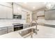 Modern kitchen with stainless steel sink and appliances, gray cabinets and white backsplash at 4000 Cheyney Park Dr, Charlotte, NC 28269