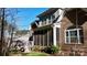 Brick home exterior featuring a screened porch with steps leading down to a beautifully landscaped backyard at 407 Blue Bay Ct, York, SC 29745