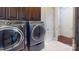 Convenient laundry room with modern washer and dryer, dark cabinets, and neutral tile flooring at 407 Blue Bay Ct, York, SC 29745