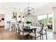 Bright dining room with large table, modern light fixture, and access to backyard patio at 504 Meadow Ridge Dr, Belmont, NC 28012