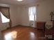 Cozy bedroom with hardwood floors, white walls, and natural light from bright windows at 515 N Pine Ln, Wadesboro, NC 28170