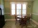 Cozy breakfast nook with a round wooden table set and natural light streaming through the multiple windows at 515 N Pine Ln, Wadesboro, NC 28170