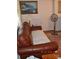 Living room with brown leather sofa and a floor fan at 515 N Pine Ln, Wadesboro, NC 28170