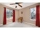 Bedroom with two windows, ceiling fan, and red curtains at 5681 Berry Ridge Dr, Harrisburg, NC 28075