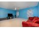 Bonus room with blue walls, sectional couch, and window at 5681 Berry Ridge Dr, Harrisburg, NC 28075