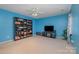 Bonus room with blue walls, ceiling fan, and built-in shelving at 5681 Berry Ridge Dr, Harrisburg, NC 28075