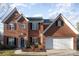 Brick two-story house with attached garage and landscaping at 5681 Berry Ridge Dr, Harrisburg, NC 28075